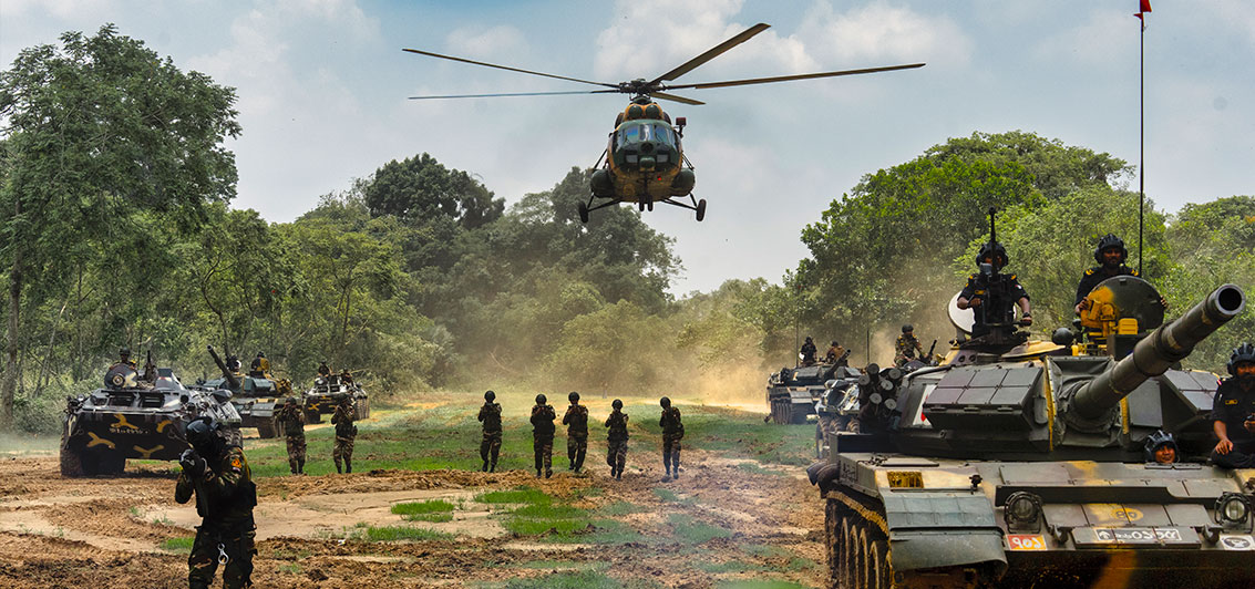 troops-armoured-vehicles-and-a-helicopter-operating-together-during-a-field-exercise--151545350.jpg